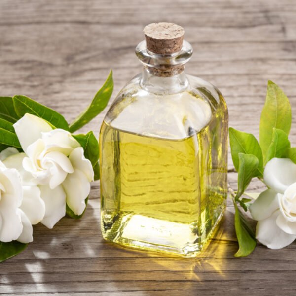 Gardenia essential oil on glass bottle with dropper on wooden table